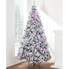 a white christmas tree with purple and green decorations