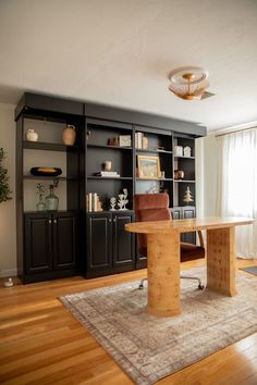 a living room filled with furniture and a large book case on top of a hard wood floor