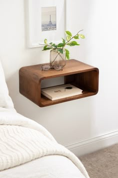 a small wooden shelf with a plant on it