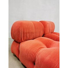 an orange couch sitting on top of a cement floor