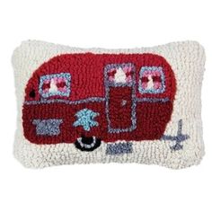 a red and white pillow with an image of a camper on it's side