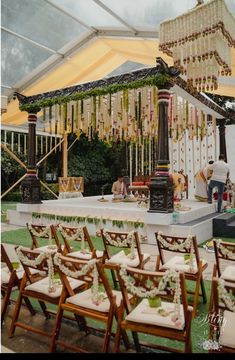 an outdoor wedding setup with chairs and chandelier