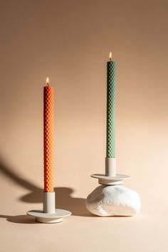 two candles sitting next to each other on top of rocks