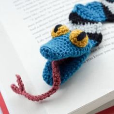 crocheted bookmarks made to look like cartoon characters are laying on an open book