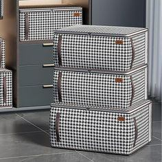 three suitcases are stacked on top of each other in front of a cabinet with drawers