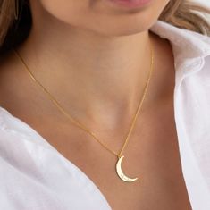 A gold crescent moon necklace is a piece of jewelry that features a pendant in the shape of a crescent moon, made from gold. The necklace is typically made with a delicate chain that complements the pendant and is worn around the neck. The crescent moon symbolizes femininity, intuition, and the cycles of life. It is a popular choice for those who appreciate celestial-inspired jewelry or want to add a touch of elegance to their outfit. The gold material adds a luxurious and timeless element to th Gold Moon-shaped Engraved Necklace, Moon Phase Jewelry For Mother's Day, Gift Necklace With Half Moon And Moon Charm, Half Moon Charm Necklaces For Gifts, Personalized Crescent Celestial Necklace, Gold Necklaces With Sun And Moon Half Moon Design, Gold Necklaces With Sun And Moon Design, Yellow Gold Crescent Charm Necklace As Gift, Crescent Moon Charm Necklace