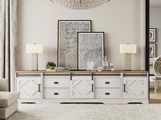 a living room with white furniture and pictures on the wall above it's dresser