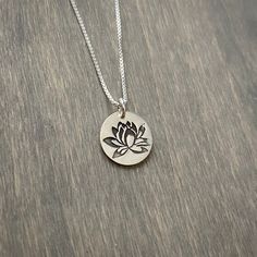 A small, stamped lotus flower pendant with an 18 inch sterling silver box chain. The pendant measures about 5/8 inch diameter. Silver Charm Necklace With Flower Charm, Sterling Silver Charm Necklaces With Flower Pendant, Sterling Silver Charm Necklace With Flower Pendant, Sterling Silver Medallion Necklace With Flower Charm, Silver Charm Necklace With Round Flower Charm, Sterling Silver Flower Charm Necklace With Pendant, Holistic Silver Necklace With Flower Pendant, Sterling Silver Necklace With Flower Charm Pendant, Sterling Silver Necklace With Flower Charm Round Pendant