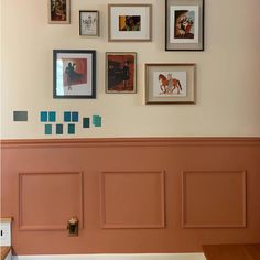 there are many pictures on the wall with different frames above them and below it is a bench