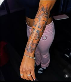 a woman with a cross tattoo on her arm