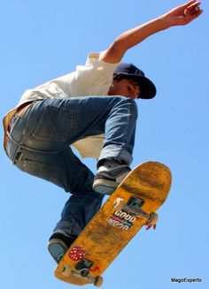 a man flying through the air while riding a skateboard in front of a blue sky