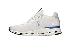 a white sneaker with blue accents on the side