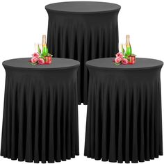 three round tables with black tablecloths and flowers