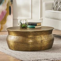 a gold coffee table sitting on top of a rug