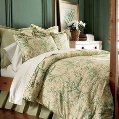 a bed with green and white comforter in a bedroom next to a window,