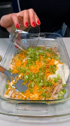 a woman pours dressing into a casserole dish with shredded cheese and green onions