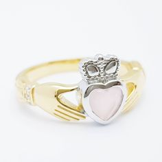 The perfect gift for yourself or someone close. Sterling silver claddagh ring set with milky pink heart shaped stone framed with white cubic zirconia in the cuffs. The hands represent friendship, the heart love and the crown stands for loyalty. This ring has been coated in a durable layer of 18k yellow gold, to maintain the color as long as possible please avoid contact with chemicals, lotions etc and keep in an airtight zip lock bag when not being worn. ----------------------------------------- Classic Pink Jewelry For Promise, Pink Hallmarked Jewelry For Valentine's Day, Pink Promise Jewelry With Birthstone, Pink Promise Ring With Birthstone, Pink Birthstone Jewelry For Promise, Promise Jewelry With Heart Cut And Polished Finish, Polished Heart Cut Promise Jewelry, Pink Rings With Polished Finish For Gift, Heart Cut Polished Jewelry For Promise