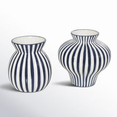 two black and white striped vases sitting next to each other on a white surface