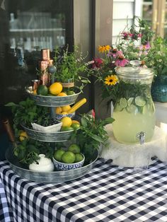 three tiered trays filled with fruit and vegetables on a table outside the house