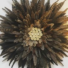 a clock made out of feathers on a wall