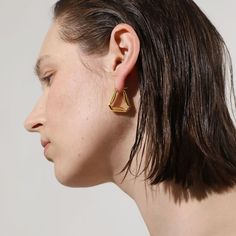 A confident style never goes unnoticed–allow your personality to shine through with these folded triangle hoop earrings, an ode to those who love retro-geometric shapes and artistic creativity. A subversive-basic design blended with wearability gives these hoops endless possibilities.

Size: 24x24mm
Material: 18k Gold Plated On Brass Modern Triangle Gold Hoop Earrings, Trendy Gold Triangle Earrings, Minimalist Triangle Hoop Earrings As Gift, Trendy Triangle Earrings, Modern Triangle Metal Earrings, Everyday Gold Triangle Earrings, Minimalist Triangle Earrings For Everyday, Modern Triangle Earrings For Party, Modern Geometric Gold Hoop Earrings