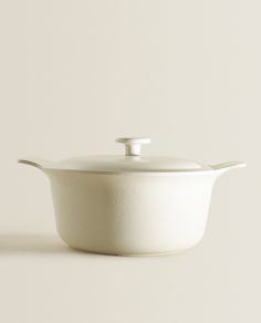 a white casserole dish with a lid and spoon on the side, against a light gray background