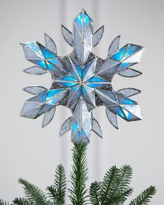 a snowflake ornament hanging from a christmas tree