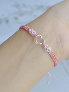 a woman's arm with a pink and white beaded bracelet on her wrist