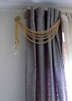 a curtain with chains hanging from it's side in front of a window,