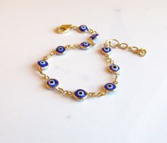 Blue and Gold Evil Eye Bracelet, Protection Bracelet, Trending Evil Eye Jewelry, Personalized Adjustable Bracelet in Blue, Friendship Gift ::THE DETAILS"" --Beautiful quality chain is made with 24kt gold heavily plated over brass. --Petite, blue, white and black evil eye connectors are double sided and rimmed in gold. --Evil eye connectors measure 6x13mm, including the loops.   --Bracelet chain is lightweight. --Bracelet closes with a 14kt gold filled lobster clasp. --Bracelet extender chain is Nickel-free Blue Charm Bracelet For Gift, Blue Nickel-free Charm Bracelet As Gift, Nickel-free Blue Charm Bracelet Gift, Adjustable Blue Evil Eye Bracelet, Nickel Free, Adjustable Blue Evil Eye Bracelet Nickel Free, Adjustable Nickel-free Blue Evil Eye Bracelet, Blue Adjustable Bracelet Jewelry, Adjustable Nickel-free Blue Chain Bracelet, Adjustable Blue Nickel-free Chain Bracelet