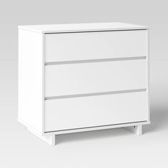 a white dresser with three drawers on it's sides and one drawer open to show the