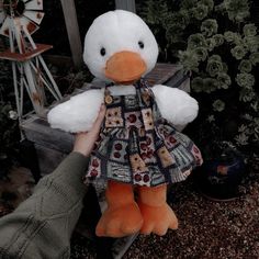 a person holding a stuffed duck in their hand