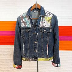 a jean jacket is hanging on a clothes rack next to an orange and white striped wall