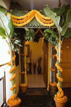 an entrance decorated with yellow flowers and greenery