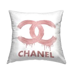 a chanel pillow with pink paint dripping down the front and bottom, on a white background