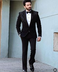 a man in a tuxedo is walking down the street