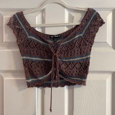 a brown crop top hanging on a white door