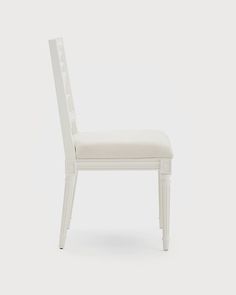 a white chair with a back and seat upholstered to it's side