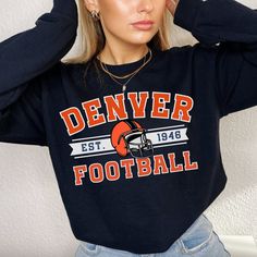 Perfect sweatshirt for Denver Bronco football fans this season! Ideal for any situation, a unisex heavy blend crewneck sweatshirt is pure comfort. These garments are made from polyester and cotton. This combination helps designs come out looking fresh and beautiful. The collar is ribbed knit, so it retains its shape even after washing. There are no itchy side seams on these sweaters.  .: 50% cotton, 50% polyester .: Medium-heavy fabric (8.0 oz/yd² (271.25 g/m .: Loose fit .: Sewn-in label .: Runs true to size CARE INSTRUCTIONS: -Please wash all clothing items INSIDE OUT to preserve the design. -Please wash all clothing items on cold, and dry on Medium- low heat. -DO NOT IRON. -DO NOT TIE DYE. **Please check our color and size charts before you place your order. If you have any questions pl Team Logo Sweatshirt For Sports Events In Fall, Game Day Crew Neck Sweatshirt, Game Day Crew Neck Sweatshirt For Sports Season, Fan Apparel Sweatshirt With Letter Print For Game Day, Crew Neck Sweatshirt For Game Day, Sports Fan Gear Sweatshirt For Sports Season, Fan Gear Sports Season Sweatshirt, Fan Gear Sweatshirt For Sports Season, Varsity Crew Neck Sweatshirt For Football Season