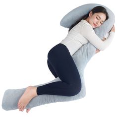 a woman laying on top of a pillow with her arms wrapped around the back and head