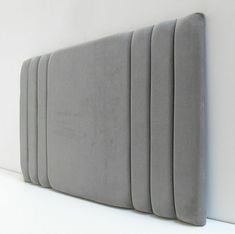 an upholstered headboard is shown against the wall with no sheets on it