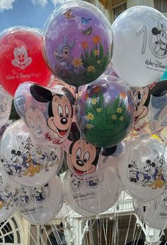 mickey mouse balloons are on display at an amusement park