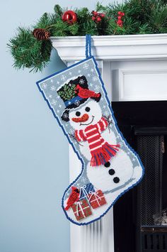 a christmas stocking hanging from a fireplace with a snowman on it's side