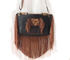 Reflecting western style, this western bag is the perfect accessory for those who love cowboy and rodeo themes. An elegant and stylish crossbody bag made of high quality leather material. Ideal for daily use, this bag is both practical and fashionable.  Ideal for festivals and outdoor events, this bag is made of durable black and brown leather. It offers comfortable use with its lightweight and useful design. It was also designed for those who embrace both Native American culture and Bohemian st Western Brown Bag With Adjustable Strap, Western Style Crossbody Shoulder Bag For Travel, Western Brown Bag With Fringe, Brown Rectangular Bag For Rodeo, Rectangular Brown Bag For Rodeo, Brown Western Bag With Fringe, Western Brown Satchel Shoulder Bag, Western Style Crossbody Bags For Western-themed Events, Western Brown Shoulder Bag With Adjustable Strap