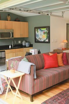 a living room filled with furniture next to a kitchen