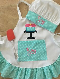 a child's apron, hat and utensil are laying on the floor