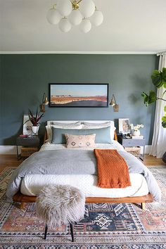 a bedroom with a bed, rugs and pictures on the wall above it is shown