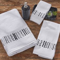 three white towels sitting on top of a wooden table