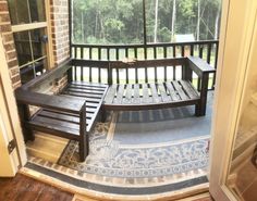 a wooden bench sitting in front of a window on top of a hard wood floor