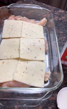 several pieces of cheese sitting in a plastic container on a counter top next to a package of chicken